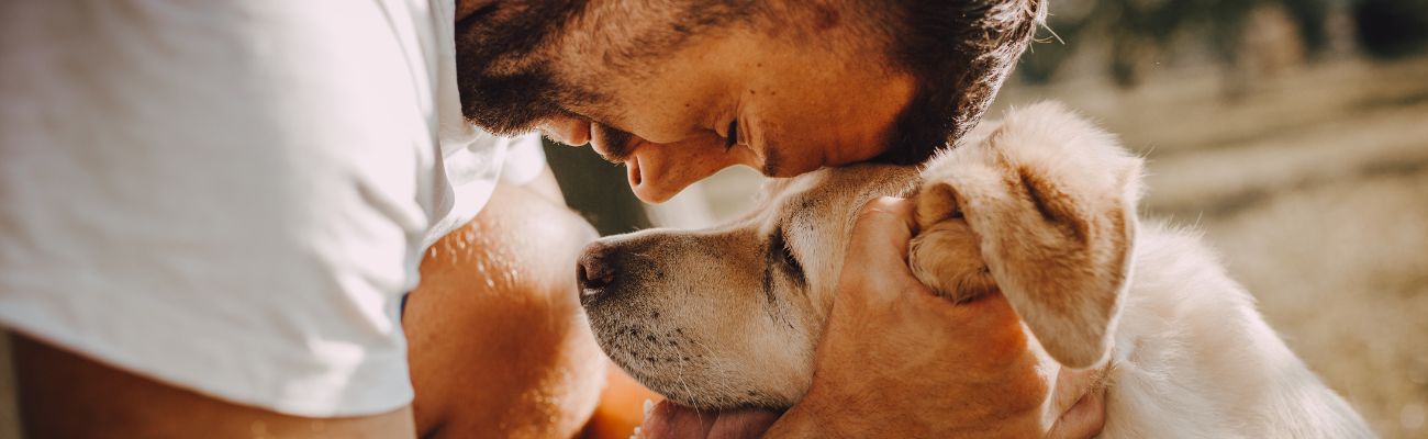 mann-mit-hund-in-liebevoller-geste