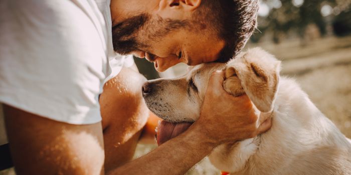 mann-mit-hund-in-liebevoller-geste
